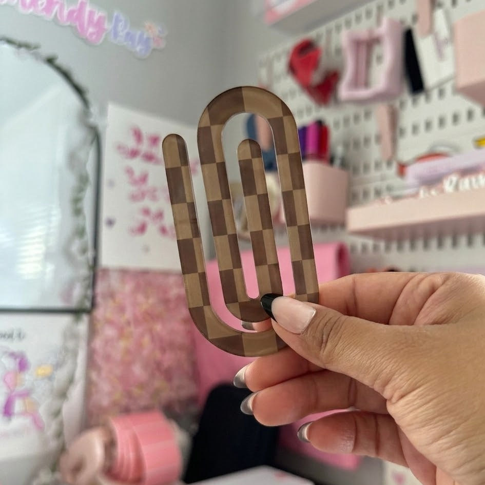Hand holding a wooden pixelated fork-shaped object in a colorful room.